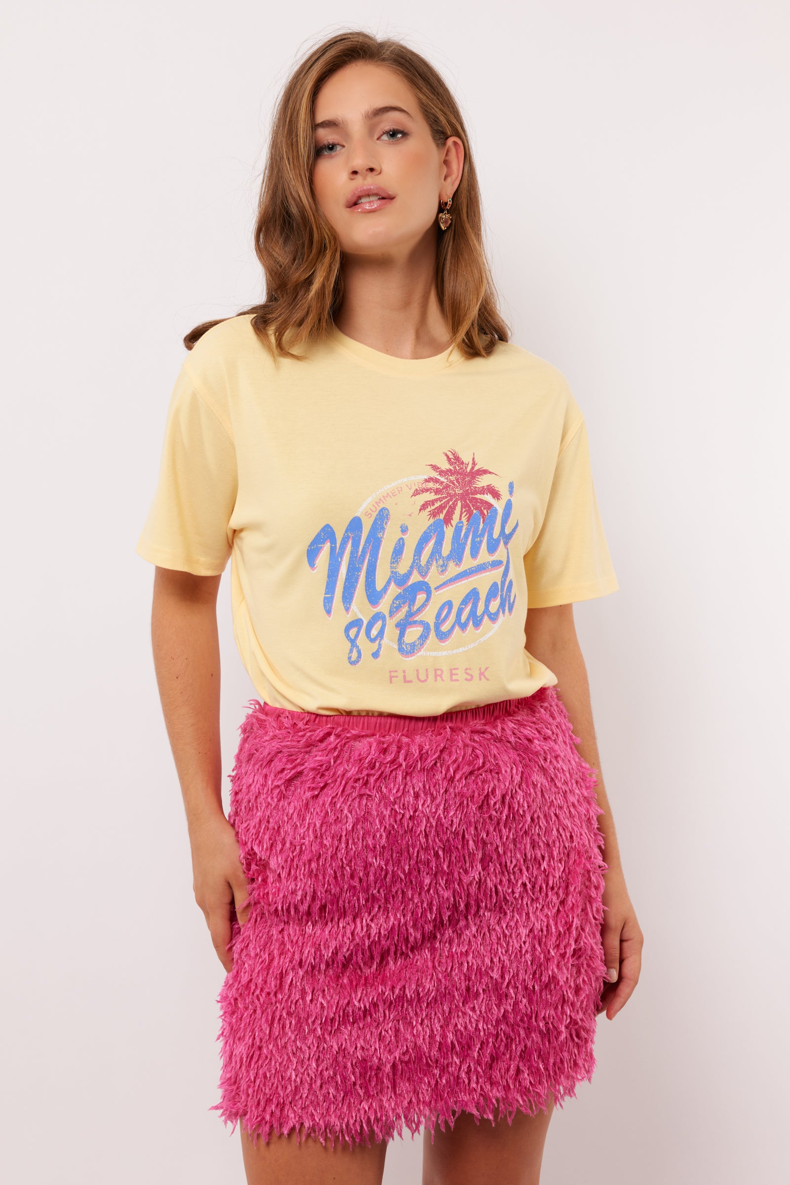 Zomerse outfit met het pastelgele Annora T-shirt van Fluresk – combineer met een roze rok voor een vrolijke look.