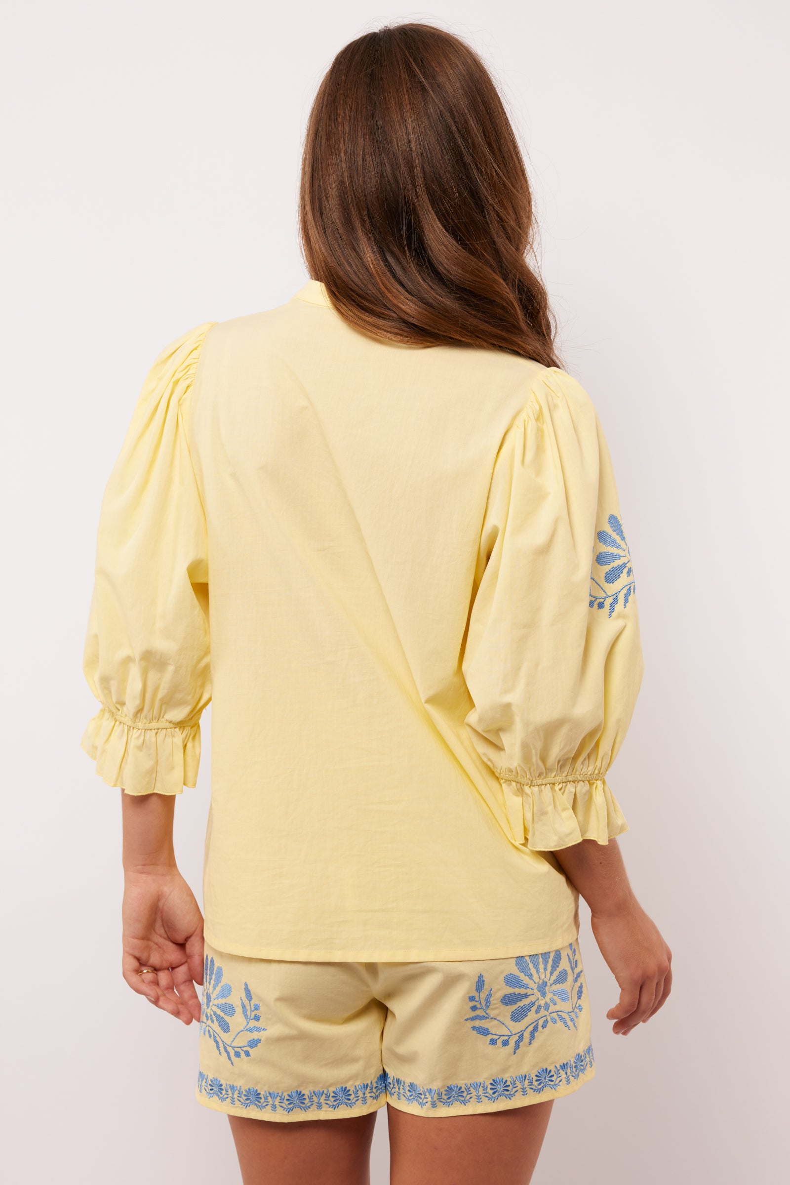 Achterkant van de Fluresk Marlowe blouse in geel met pofmouwen en bijpassende short.