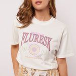 Model draagt het Soraya T-shirt van Fluresk met een witte basis en kleurrijke 'West Coast Fluresk' print.