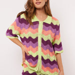 Model draagt de Whitney Blouse van Fluresk met golvend gehaakt patroon en knoopsluiting, gezien van voren.