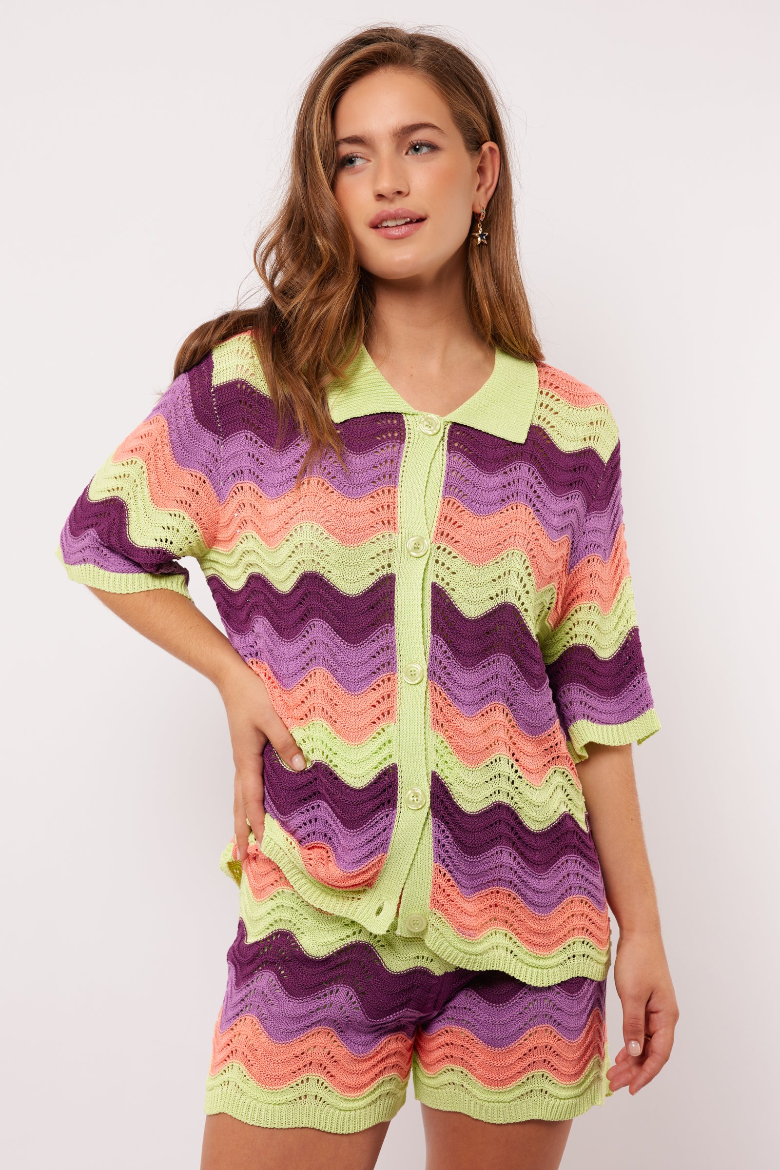 Model draagt de Whitney Blouse van Fluresk met golvend gehaakt patroon en knoopsluiting, gezien van voren.