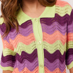 Close-up van de kraag en knopen van de Whitney Blouse van Fluresk, met een gehaakt patroon in meerdere kleuren.
