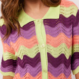 Close-up van de kraag en knopen van de Whitney Blouse van Fluresk, met een gehaakt patroon in meerdere kleuren.