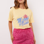 Zomerse outfit met het pastelgele Annora T-shirt van Fluresk – combineer met een roze rok voor een vrolijke look.